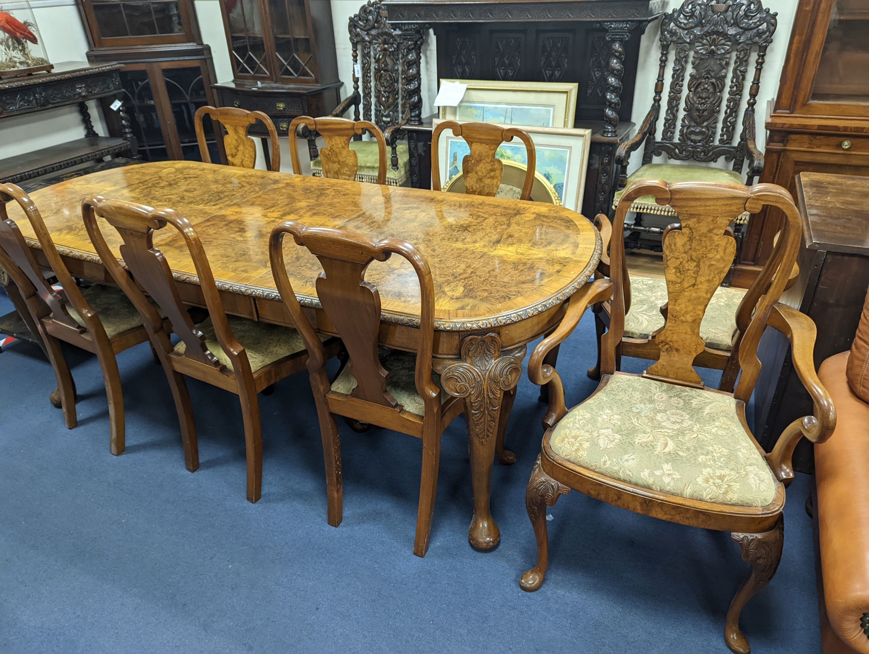 A Queen Anne revival burr walnut dining suite, comprising serpentine sideboard, length 168cm, depth 56cm, height 98cm, extending dining table, 210cm extended, one spare leaf, width 90cm, height 75cm and eight chairs, two